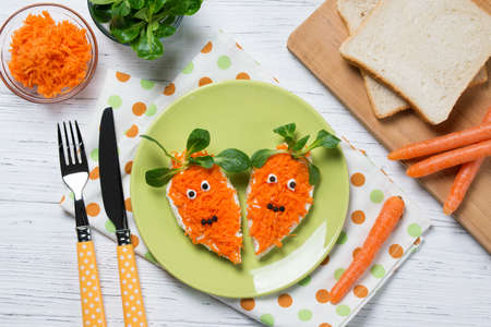 Funny toasts in a shape of carrots, food for kids Easter idea, top viewの写真素材