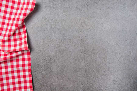 Red checkered tablecloth on vintage gray stone table, top viewの写真素材