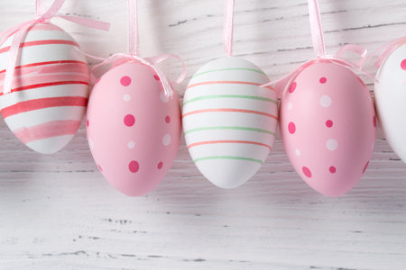 Pink easter eggs hanging on a wooden background, closeupの写真素材