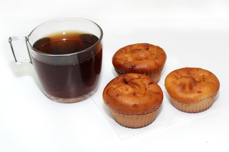 as far as muffins with tea or coffee on white tableの写真素材