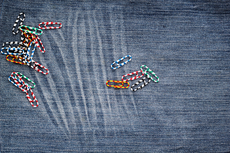 Set of colorful paperclips on a jeans background. Top view.の写真素材