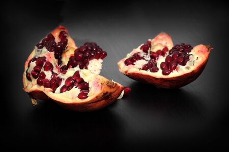 ripe pomegranate fruit on black backgroundの写真素材