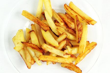 fried potatoes on a glass plate white backgroundの写真素材