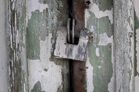 Old wooden door of the barn with a rusty padlockの写真素材