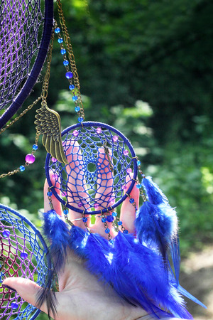 photo of a dreamcatcher made by hand, with using threads, beads and feathers roosterの写真素材