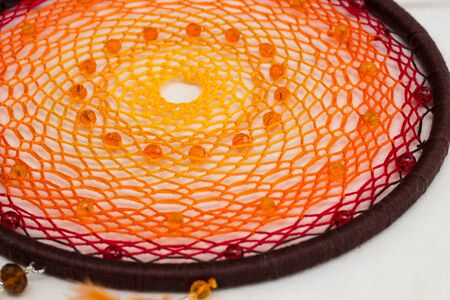 Beautiful orange dream catcher on white backgroundの写真素材