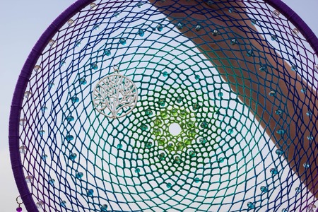 photo of a dreamcatcher made by hand, with using threads, beads and feathers roosterの写真素材