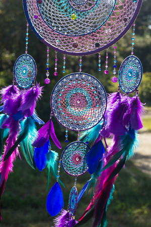 photo of a dreamcatcher made by hand, with using threads, beads and feathers roosterの写真素材