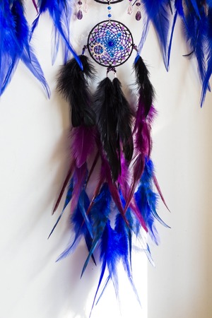 photo of a dreamcatcher made by hand, with using threads, beads and feathers roosterの写真素材