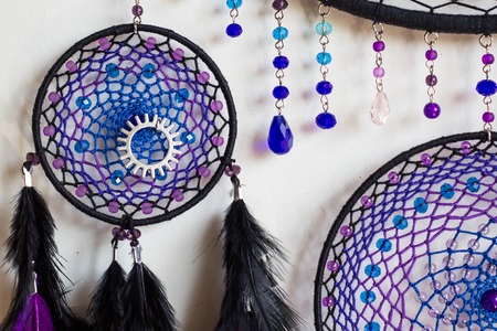photo of a dreamcatcher made by hand, with using threads, beads and feathers roosterの写真素材
