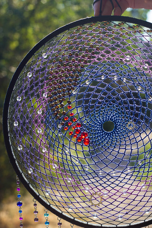 photo of a dreamcatcher made by hand, with using threads, beads and feathers roosterの写真素材