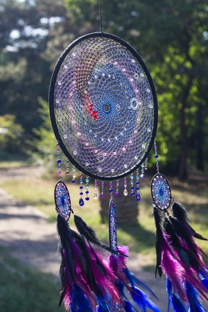 photo of a dreamcatcher made by hand, with using threads, beads and feathers roosterの写真素材