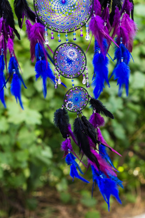 photo of a dreamcatcher made by hand, with using threads, beads and feathers roosterの写真素材