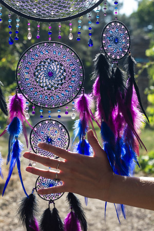 photo of a dreamcatcher made by hand, with using threads, beads and feathers roosterの写真素材