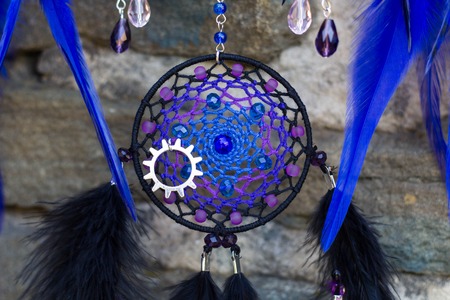 photo of a dreamcatcher made by hand, with using threads, beads and feathers roosterの写真素材