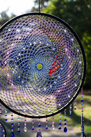 photo of a dreamcatcher made by hand, with using threads, beads and feathers roosterの写真素材