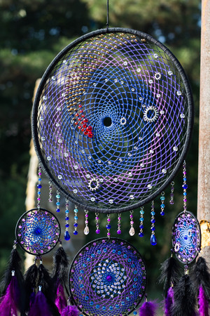 photo of a dreamcatcher made by hand, with using threads, beads and feathers roosterの写真素材