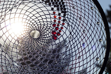 photo of a dreamcatcher made by hand, with using threads, beads and feathers roosterの写真素材