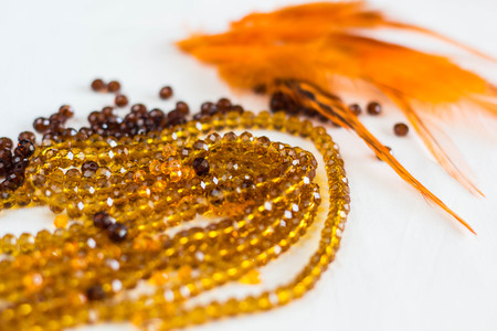 Beautiful colored glass beads and thread beads. feathers on white backgroundの写真素材