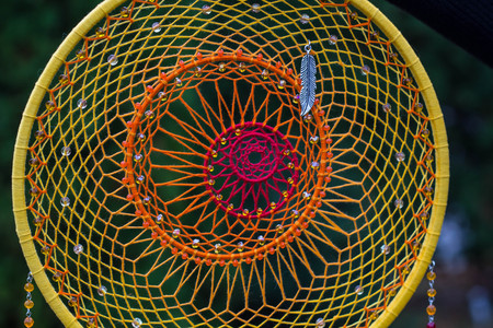photo of a dreamcatcher made by hand, with using threads, beads and feathers roosterの写真素材