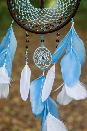 photo of a dreamcatcher made by hand, with using threads, beads and feathers roosterの写真素材