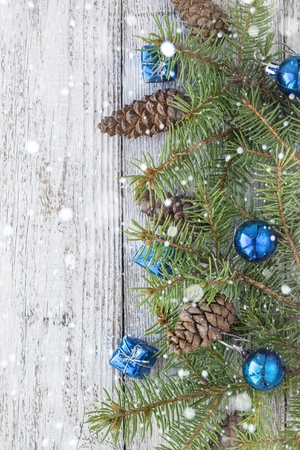 Christmas accessories in blue, cone and fir branches on wooden white backgroundの写真素材