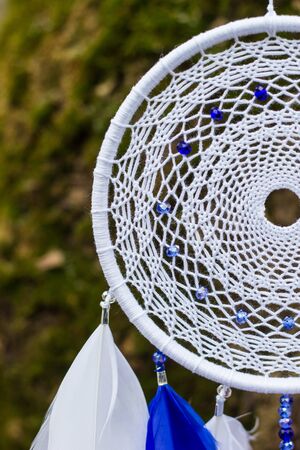 Blue and white Dreamcatcher made of feathers leather beads and ropes, hangingの写真素材