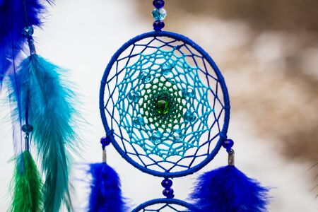 Green and blue Dreamcatcher made of feathers leather beads and ropes, hanging