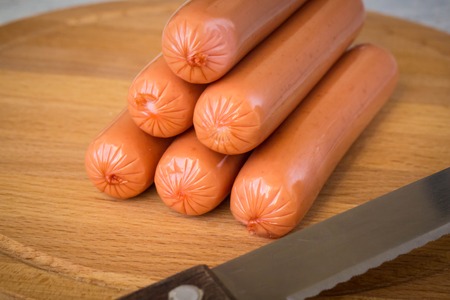 Raw Sausages on cutting Board on white rustic wooden backgroundの写真素材