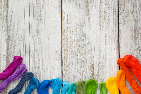 colorful sewing threads for embroidery on white wooden backgroundの写真素材