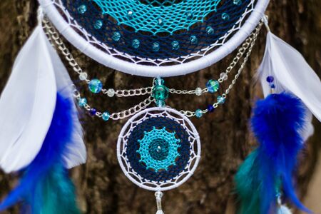 Blue and white Dreamcatcher made of feathers leather beads and ropes, hangingの写真素材