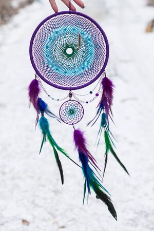 Green purple and blue Dreamcatcher made of feathers leather beads and ropes, hangingの写真素材