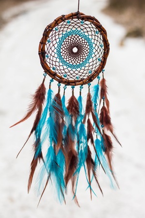 Blue and brown Dreamcatcher made of feathers leather beads and ropes, hangingの写真素材