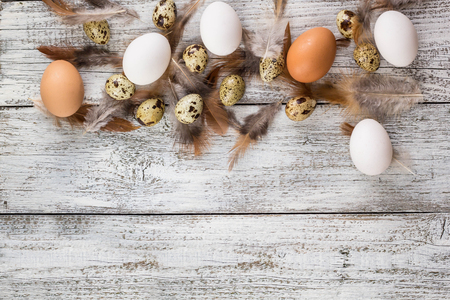 Easter background made from Easter eggs and chicken feathers frame. Copy space.の写真素材