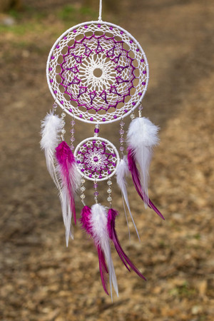 Red black and purple Dreamcatcher with bat made of feathers leather beads and ropes, hangingの写真素材