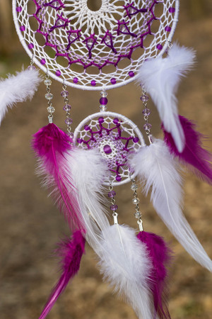 Red black and purple Dreamcatcher with bat made of feathers leather beads and ropes, hangingの写真素材