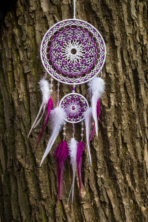 Red black and purple Dreamcatcher with bat made of feathers leather beads and ropes, hangingの写真素材