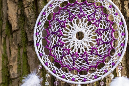 Red black and purple Dreamcatcher with bat made of feathers leather beads and ropes, hangingの写真素材