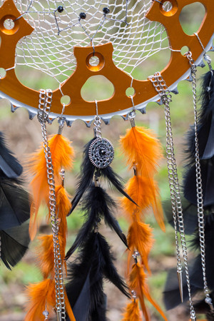black and orange Dreamcatcher with motorcycle star made of feathers leather beads and ropes, hangingの写真素材