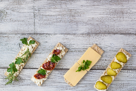various crispbread slices on white woden kitchen table, top viewの写真素材