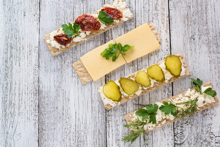 various crispbread slices on white woden kitchen table, top viewの写真素材