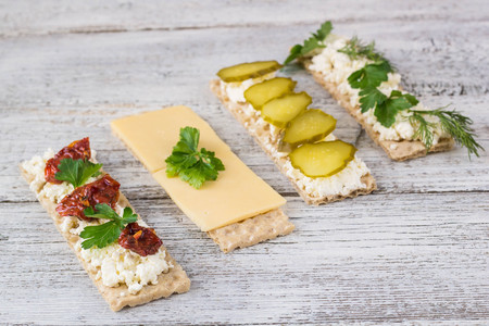 various crispbread slices on white woden kitchen table, top viewの写真素材