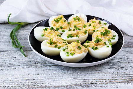 Home eggs stuffed with cheese and crab sticks topped with green onionsの写真素材