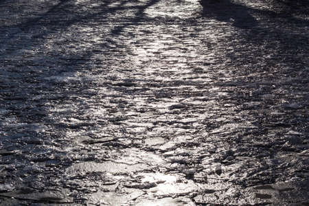 abstract reflections in melting the icy cobblestones. path of lightの写真素材