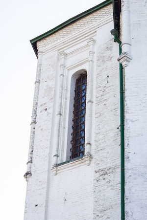 Latticed window in arches shape at white medieval church wallの写真素材