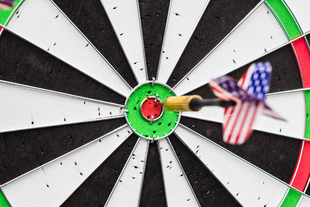 Dart arrow hitting in the red target center of dartboardの写真素材