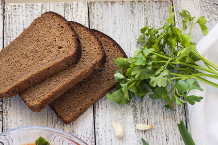 Vegetables and meat in red beetroot soup or borsch with sour cream. bread, green onion, parsley, garlic around the plate with metal spoonの写真素材
