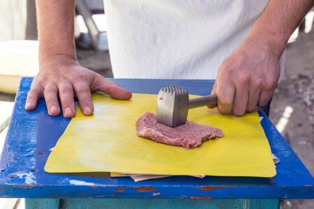 Man Beating pork chop with special aluminum hammerの写真素材