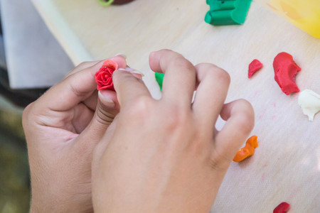 Women hands making floral jewelry from polymer clay, plasticine.の写真素材