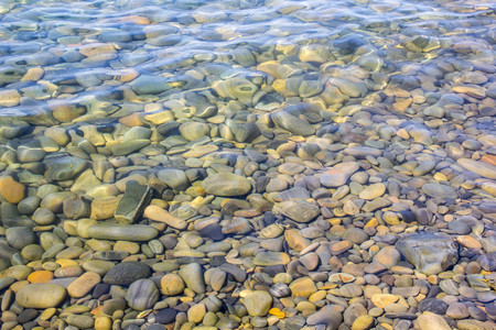 Sea and pebbles underwater in a beach. Pebble background.の写真素材